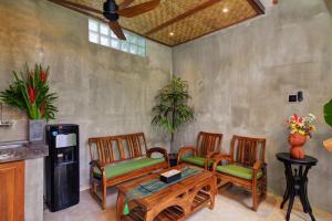 a living room with two chairs and a table and a fan at The Cottage By Selasih in Seminyak