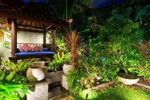 a garden with a bench and many plants at The Cottage By Selasih in Seminyak