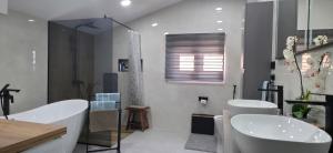 a bathroom with two sinks and a tub and a shower at Villa View in Neum