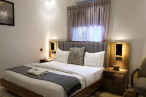 a bedroom with a large bed with a window at Black Muse Residence in Benin City
