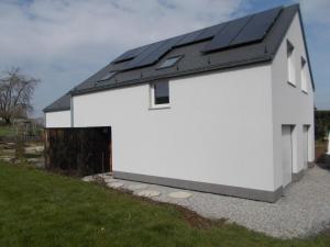 ein weißes Gebäude mit schwarzem Dach und einer Garage in der Unterkunft adoreu in Dinant