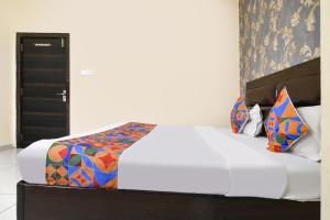 a bedroom with a white bed with colorful pillows at FabHotel Shree I in Indore