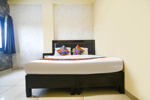 a bed with two pillows on it in a room at FabHotel Shree I in Indore +29 photos