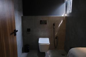 a small bathroom with a toilet and a shower at Black Muse Residence in Benin City