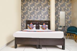 a bed in a room with a wall at FabHotel Shree I in Indore