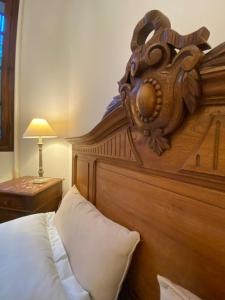 a bed with a wooden headboard in a bedroom at Domaine Lainault - Logement des Vignerons in Lhomme +27 photos