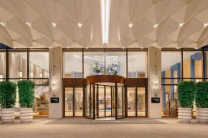 a lobby of a building with glass doors and plants at Le Méridien Changzhou in Changzhou +50 photos