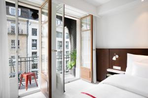ein Schlafzimmer mit Bett und Balkon in der Unterkunft Ruby Claire Hotel Geneva by IHG in Genf