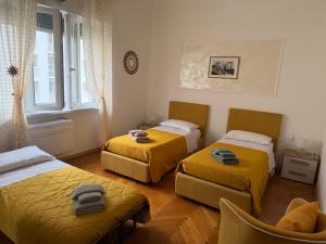 a room with three beds and a window at SoleMare Rooms Trieste in Trieste