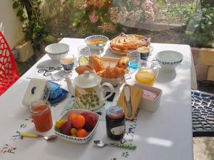 a white table with breakfast foods and drinks on it at Ty Capitaine Chambres d'hôtes Guidel in Guidel
