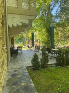 a patio with tables and chairs and tables at Vila Popovici in Prăjila