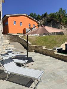 a group of lounge chairs and an umbrella on a patio at Vessa 3 in Selvapiana