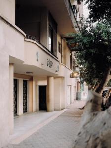 an empty street with a building and a tree at Longchamps l Zamalek l Boutique Hotel with Breakfast in Cairo