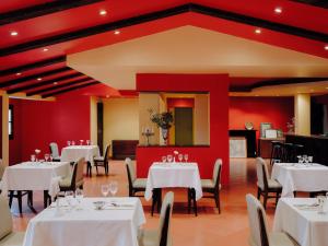 a restaurant with white tables and chairs and red walls at Longchamps l Zamalek l Boutique Hotel with Breakfast in Cairo