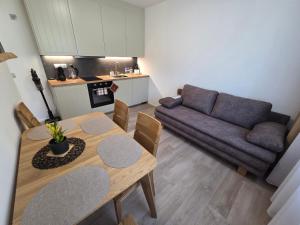 a living room with a table and a couch at Apartmán Mlýn 208 in Vrchlabí +21 photos