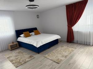 a bedroom with a bed and red curtains and rugs at Casa Runc in Şarul Dornei +10 photos