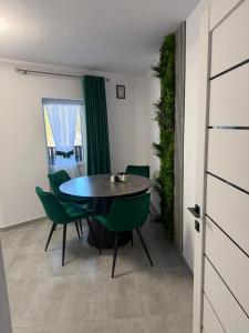 a dining room with a table and green chairs at Casa Runc in Şarul Dornei