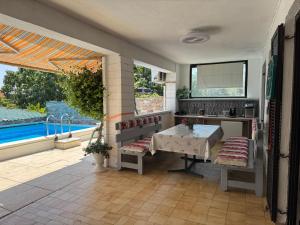 a kitchen with a table and a view of a pool at Zupan apartments in Ližnjan