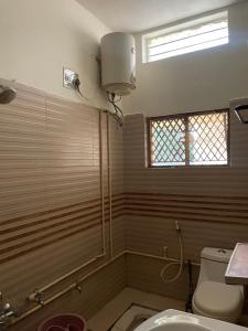 a bathroom with a shower and a toilet and a window at Mandira Homes in Mysore +8 photos