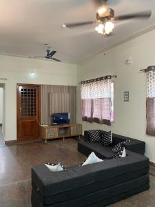 a living room with two couches and a tv at Mandira Homes in Mysore
