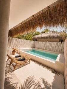 a backyard with a swimming pool and a chair and a umbrella at Villa Samalas Boutique Resort & Private Pool Villas in Gili Meno +77 photos
