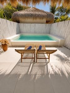 two chairs and a table next to a swimming pool at Villa Samalas Boutique Resort & Private Pool Villas in Gili Meno