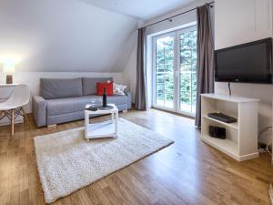 salon z kanapą i telewizorem w obiekcie VisitZakopane - Hill Apartment w Zakopanem