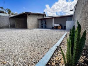 a house with a gravel driveway in front of it at Casa c/ piscina e churrasqueira para até 6 pessoas in Limeiro
