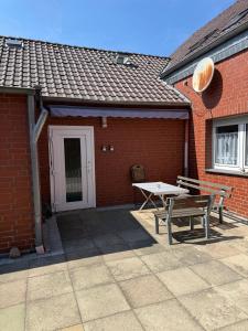 a picnic table and bench in front of a brick building at Kompaktes Studiozimmer mit Pantryküche und Fußbodenheizung in der Nähe der Messe Dusche und WC werden gemeinschaftlich genutzt in Hannover