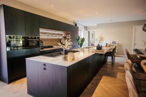 a kitchen with black cabinets and a white counter top at Resort Valley in Wekerom