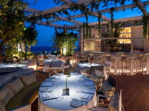a restaurant with tables and chairs and a bar at Swissôtel Resort Bodrum Beach in Turgutreis