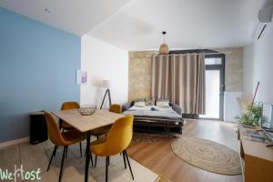 a living room with a bed and a table and chairs at Charmant cocon avec jacuzzi - Bordeaux Centre in Bordeaux