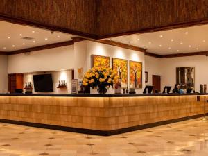 a lobby with a reception counter with a vase of flowers at Swissotel Quito in Quito