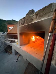 a stone pizza oven with a fire in it at Vessa 3 in Selvapiana