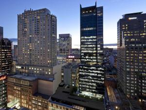 a city skyline with tall buildings at night at Swissotel Sydney in Sydney