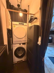 a washer and dryer in a tiny house at Independent charming studio in Gibel