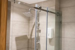a shower with a glass door in a bathroom at Hôtel Aguelmam in Khenifra