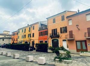 a row of colorful buildings on a city street at Cappone B&B in Morciano di Romagna