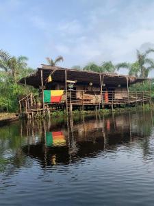 a house on a dock next to a body of water at Villa de 3 chambres avec jaccuzzi in Porto-Novo