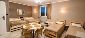 a room with two beds and a table and chairs at "Route 62" Airport Modlin 24h in Goławin +51 photos