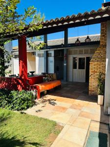 a patio with a red bench in front of a building at Casa Alemao Águas Belas in Cascavel