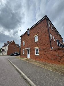 a red brick building with a white door on a street at Spacious 5BR House Free Parking hatfield in Hatfield