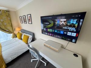 a room with a bed and a desk with a tv at Spacious 5BR House Free Parking hatfield in Hatfield