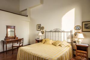 sypialnia z łóżkiem, stołem i krzesłem w obiekcie Castello di Fulignano w mieście San Gimignano