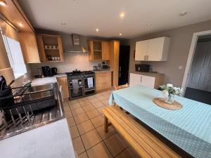 a kitchen with a table with a blue table cloth at Spacious 5BR House Free Parking hatfield in Hatfield