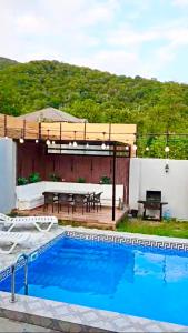 a patio with a picnic table and a swimming pool at SILAND A Frame House in Gabala