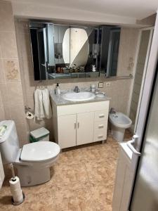 a bathroom with a toilet and a sink and a mirror at Casa villada in Villada +11 photos