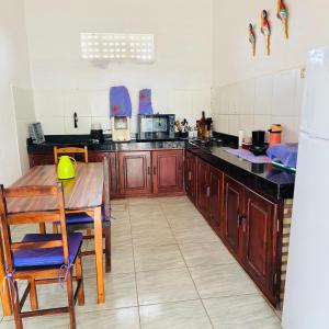 a kitchen with wooden cabinets and a table in it at Casa Alemao Águas Belas in Cascavel