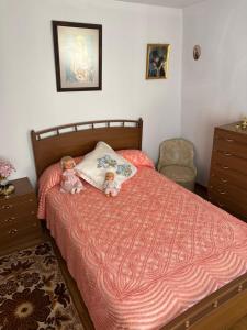 two dolls sitting on a bed in a bedroom at Casa villada in Villada