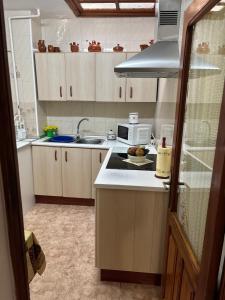 a kitchen with a sink and a microwave at Casa villada in Villada